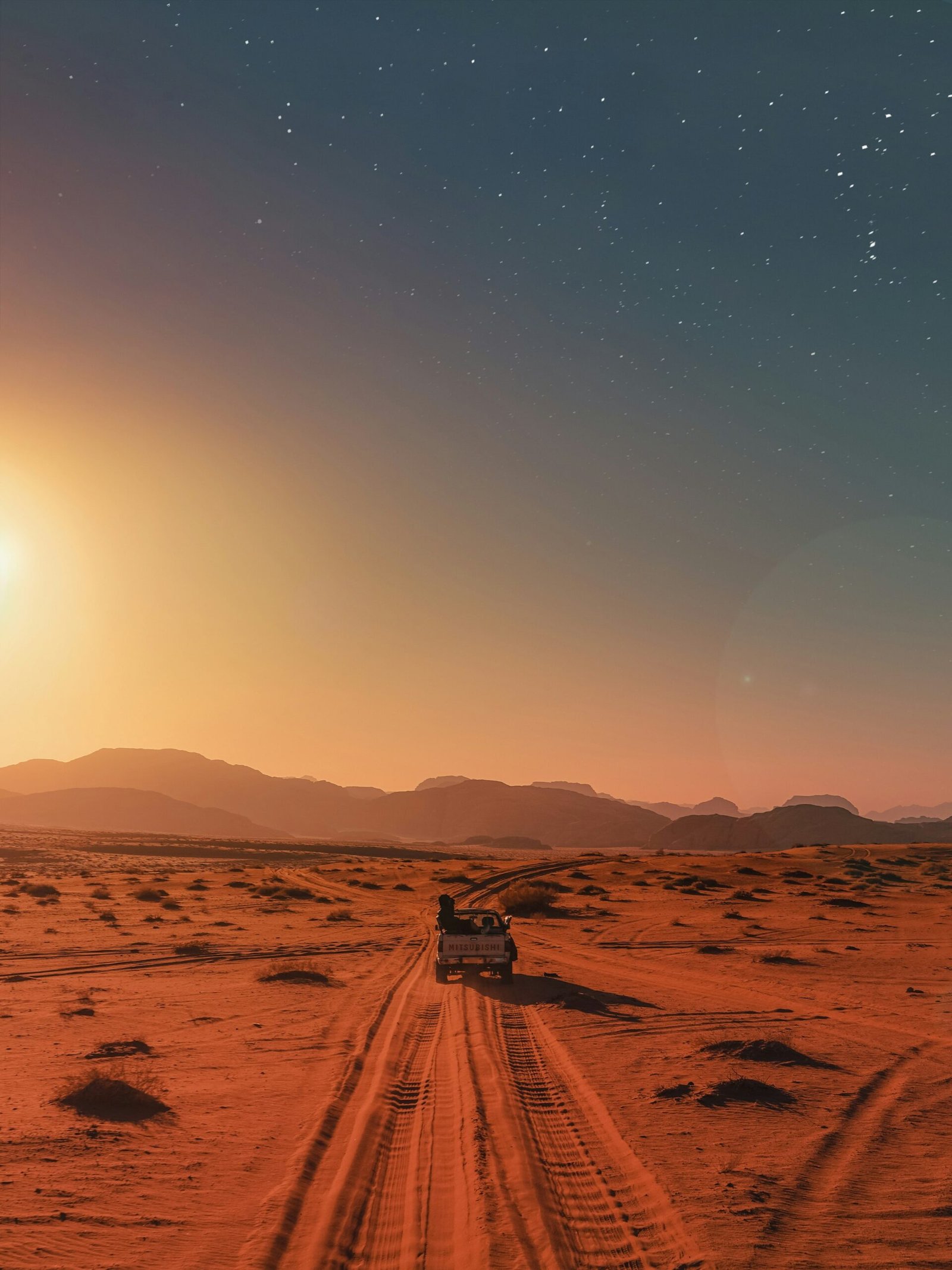 Dark car parked in the desert under intense sun
